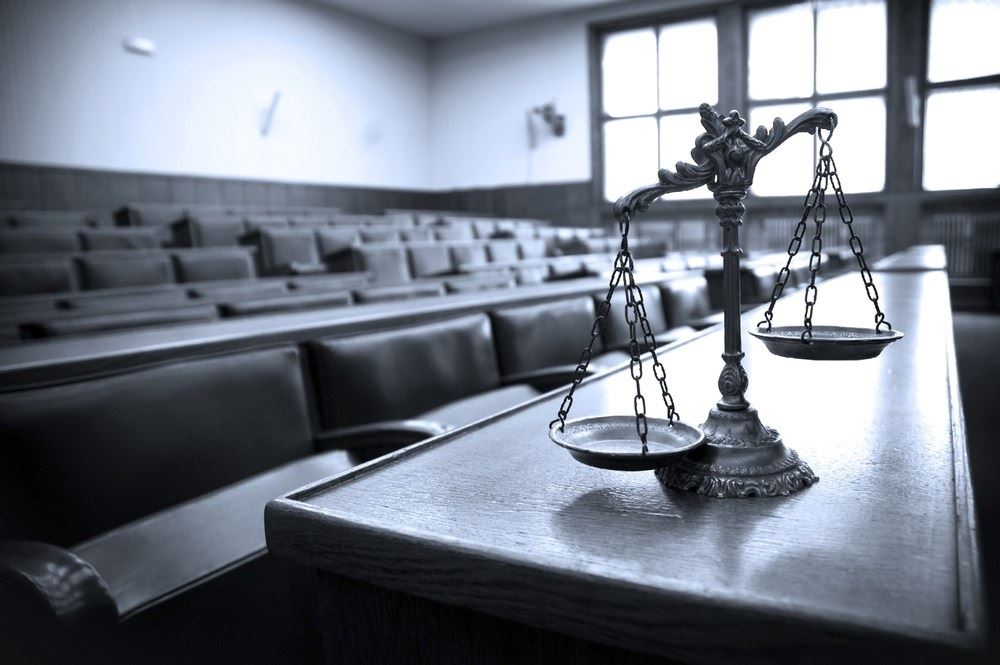 shadowy courtroom with the scales of justice