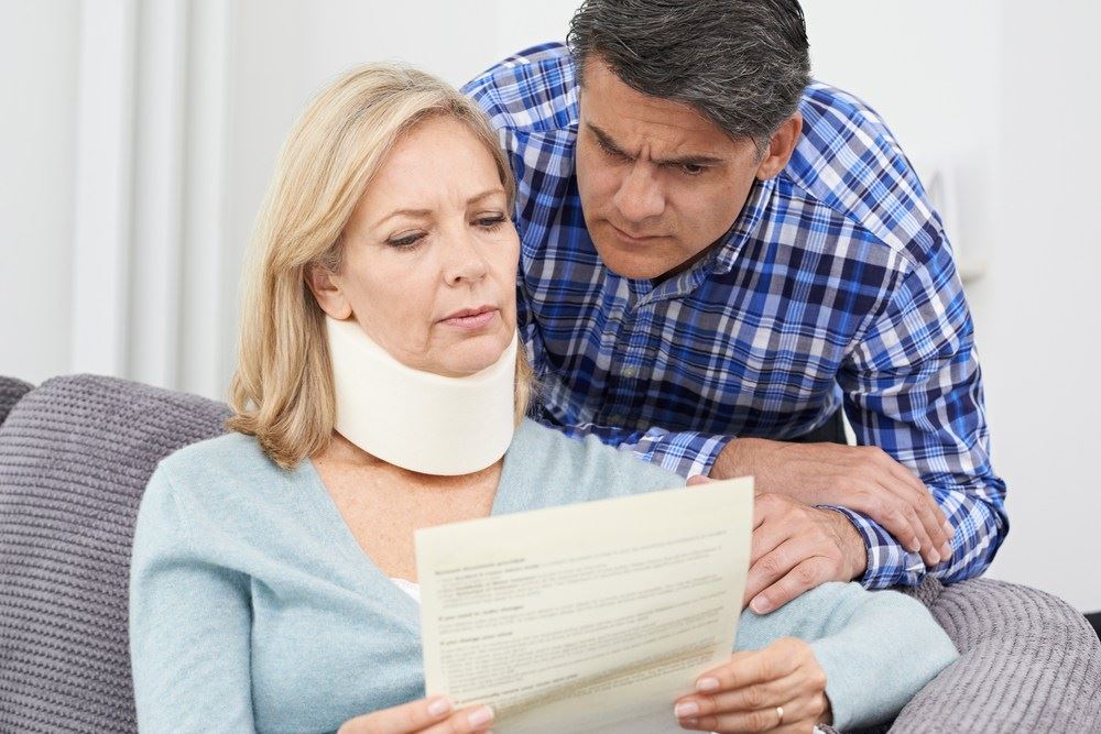 woman with injured neck reviewing her claim