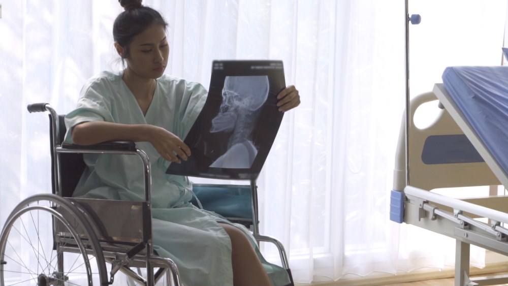 patient in wheelchair looking at x-ray image