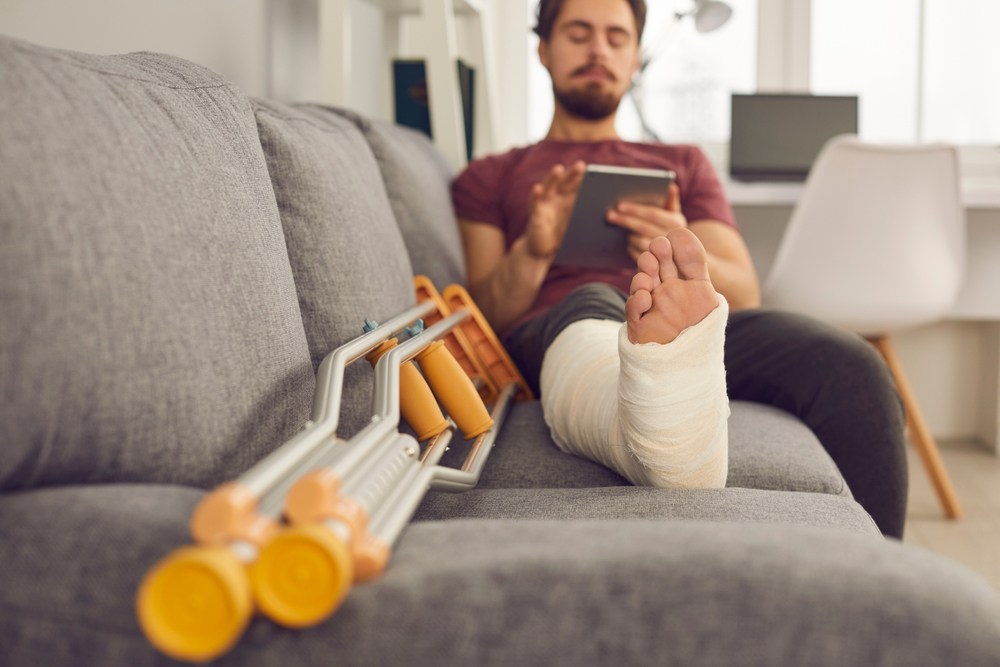 guy on the couch with his foot in a cast