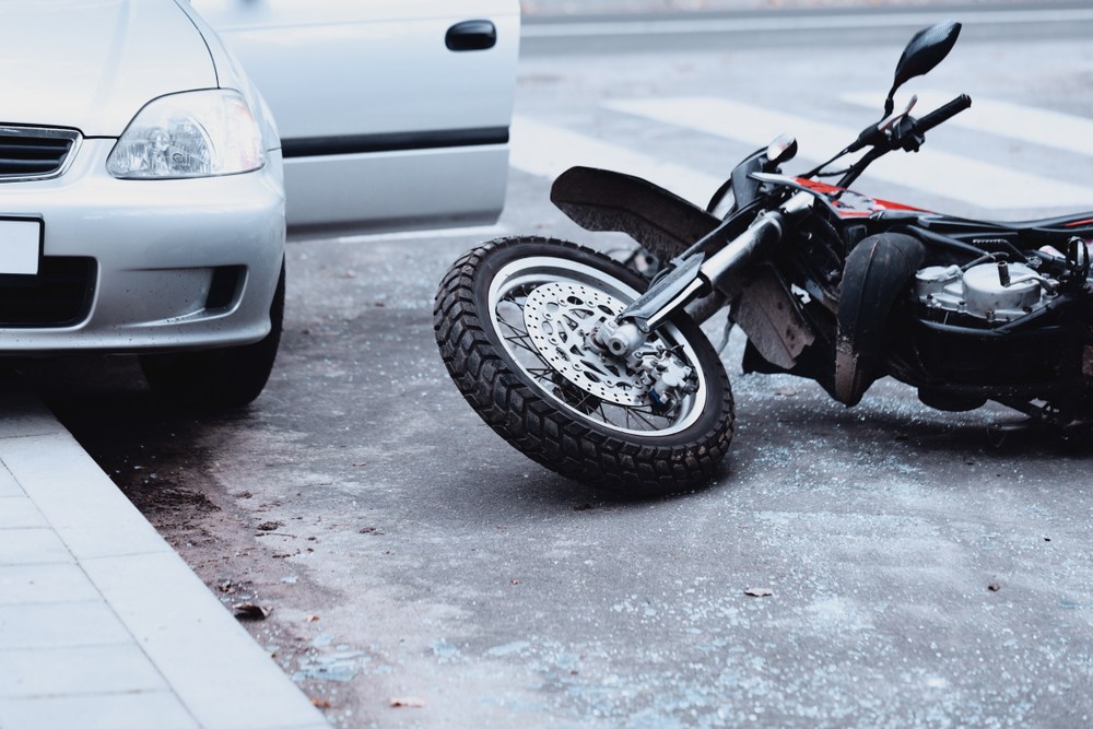 A motorcycle on the ground after a car accident.