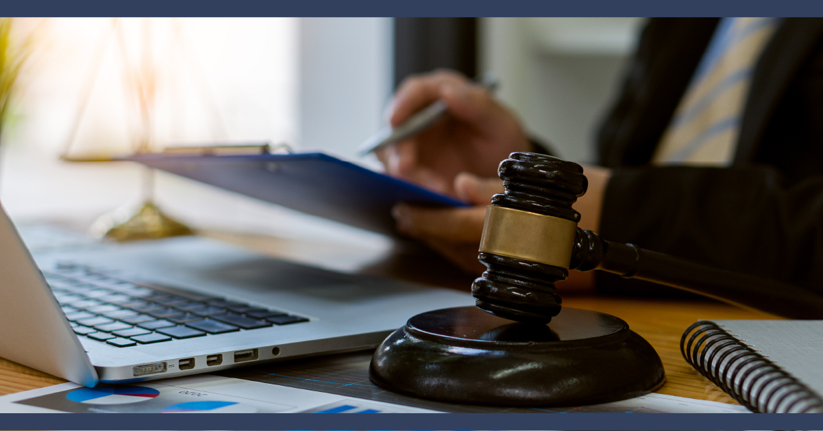 lawyer at desk holding a pen and paperwork