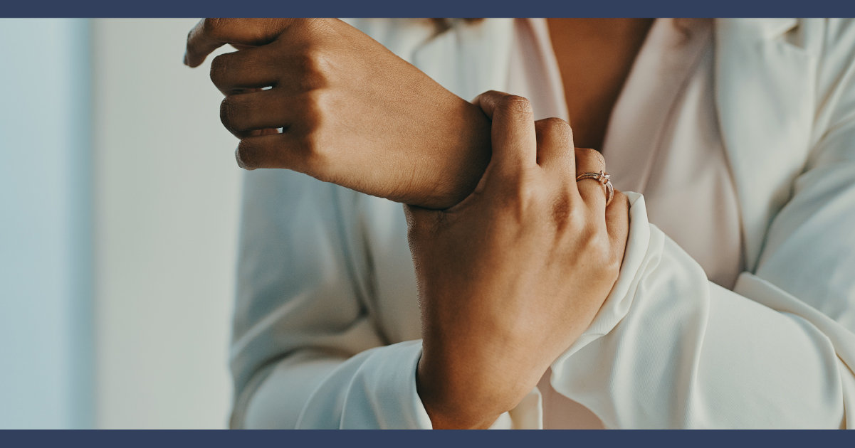 Person holding their wrist in their opposite hand, as if in pain