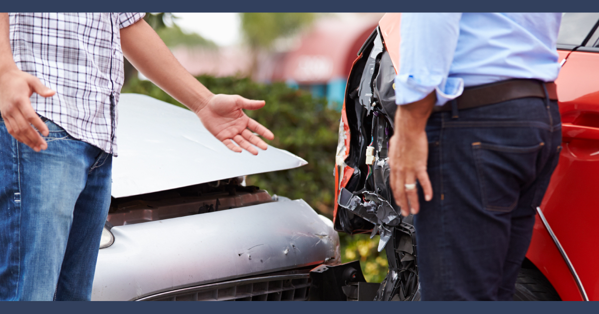 two men gesturing towards damaged car after collision