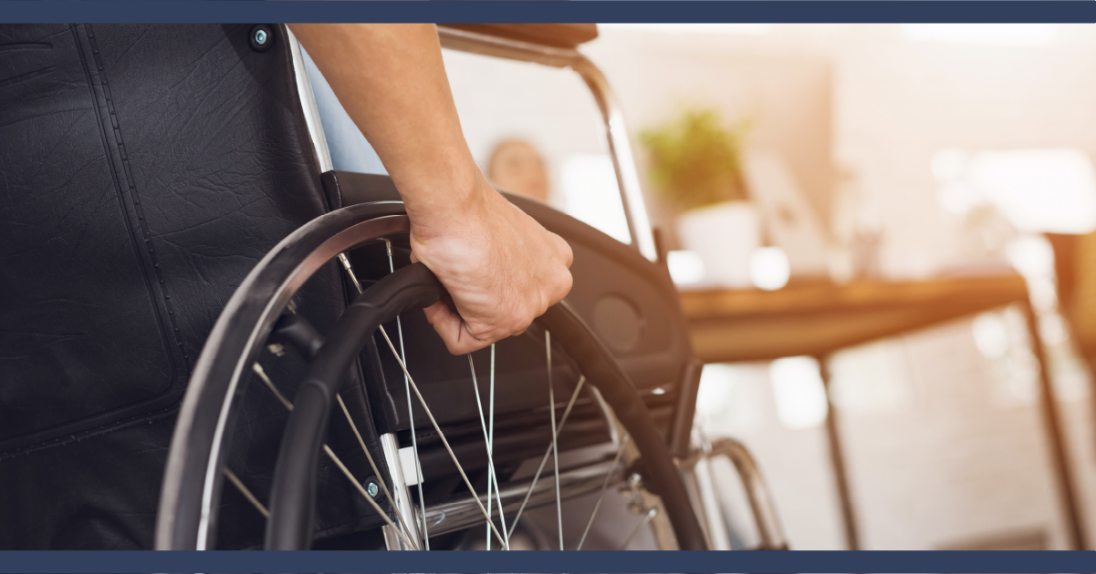 Close up of man in wheelchair approaching a office desk