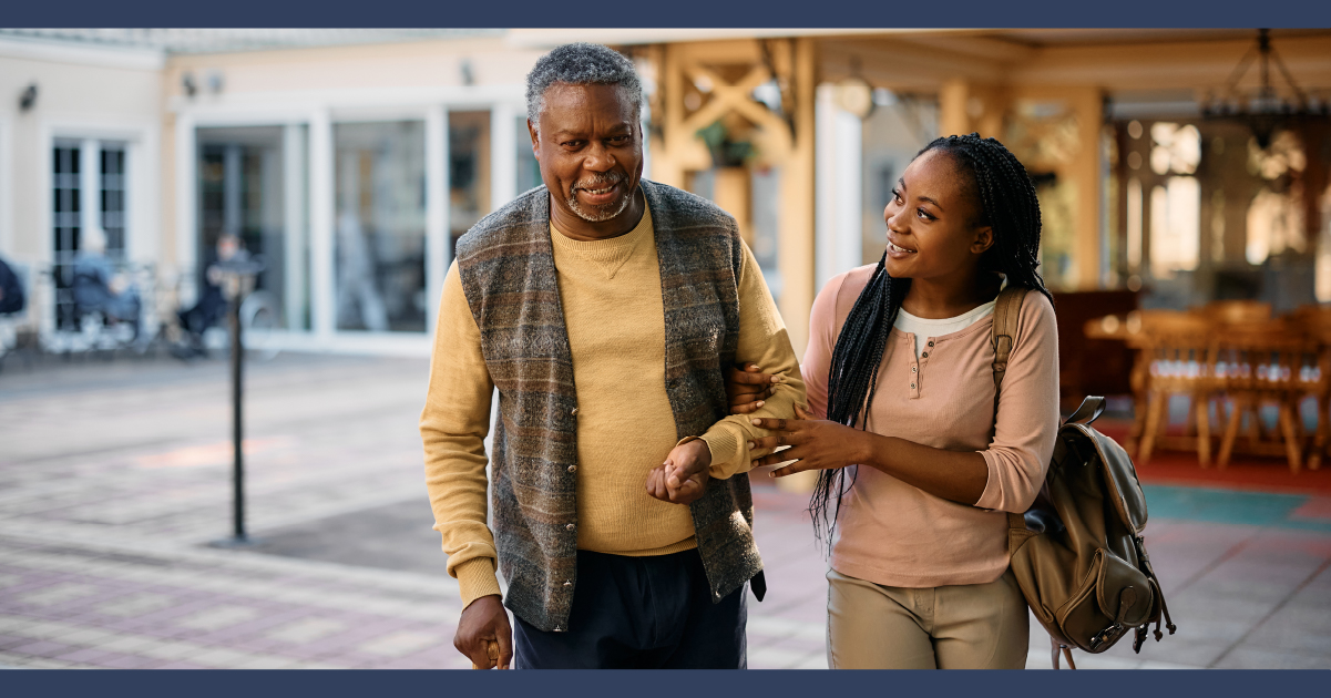 Elderly man with walking stick being helped by woman