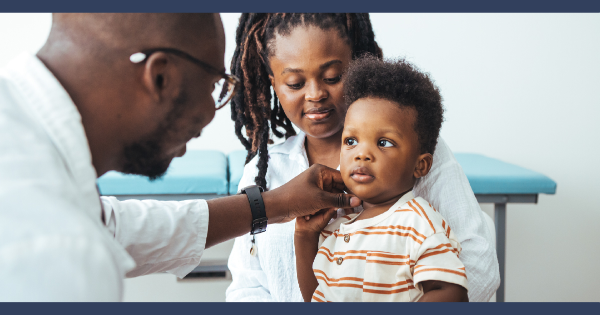 Doctor examining child while parent looks on