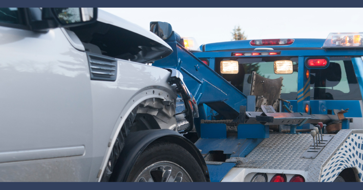 Damaged car being hauled by a tow truck