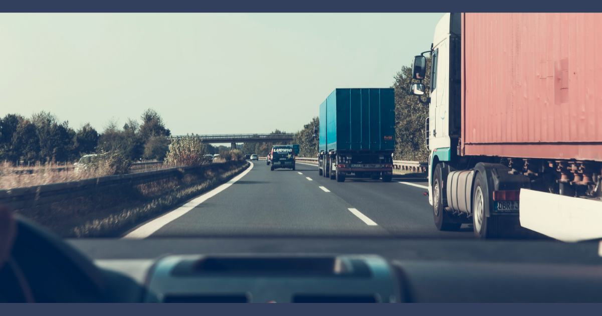 view of truck on the road from inside a car