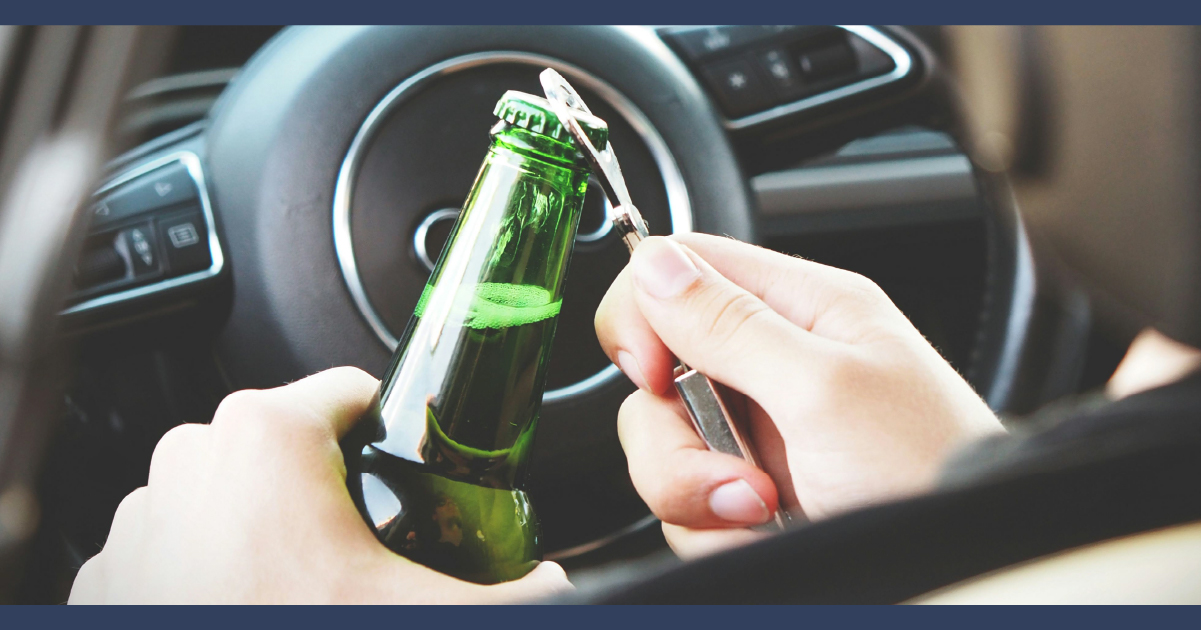 Person opening beer bottle while in the drivers seat