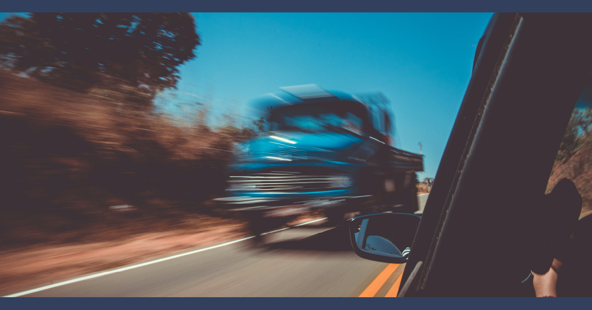 Blue truck speeding along the highway