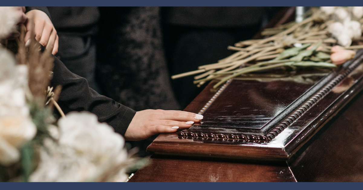 Person touching coffine at funeral
