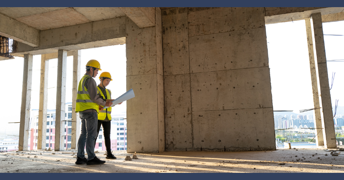 Two construction workers examining paperwork