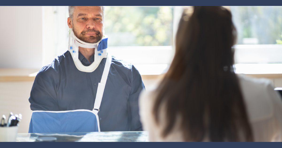 Man with his arm in a sling talking to a lawyer