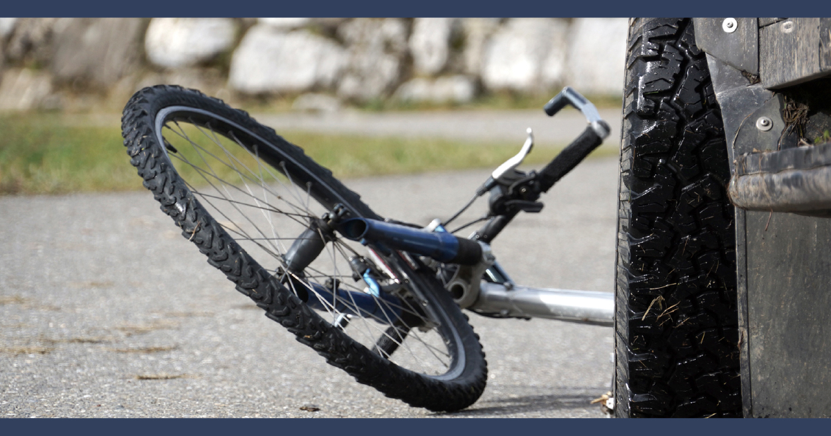 Bicycle on the ground in front of a car