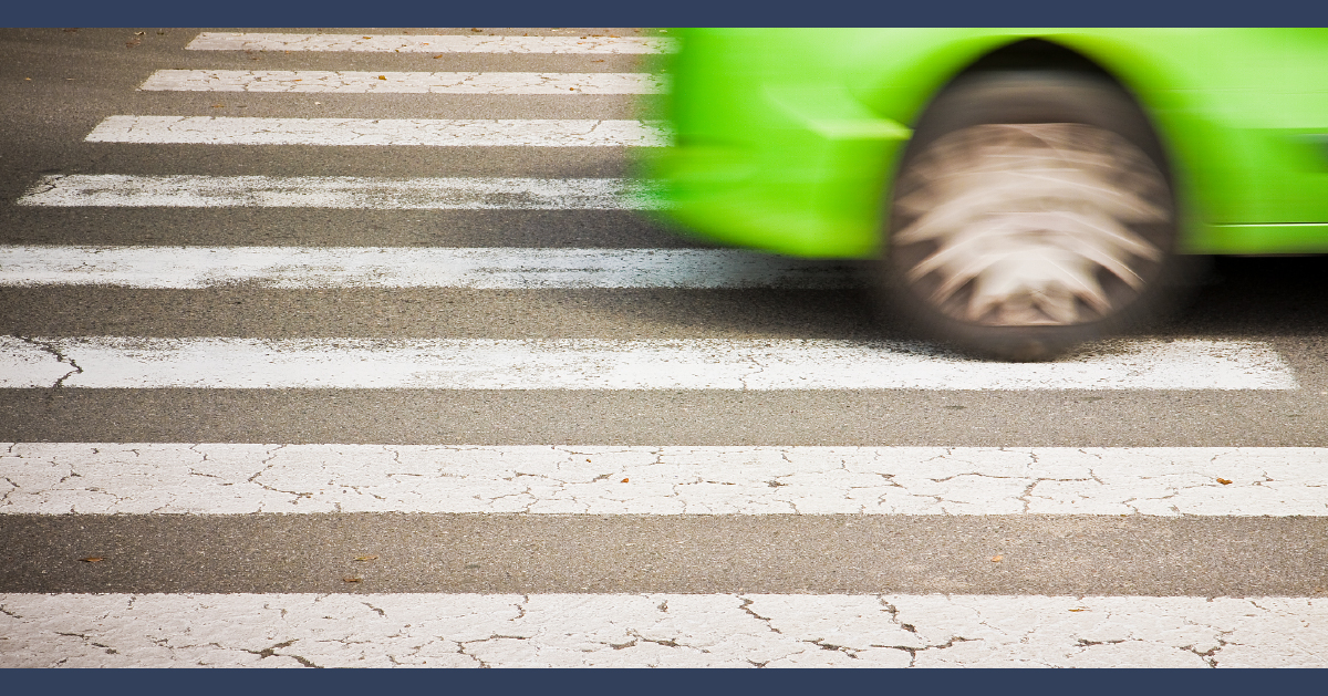 car zooming across a pedestrian crossing