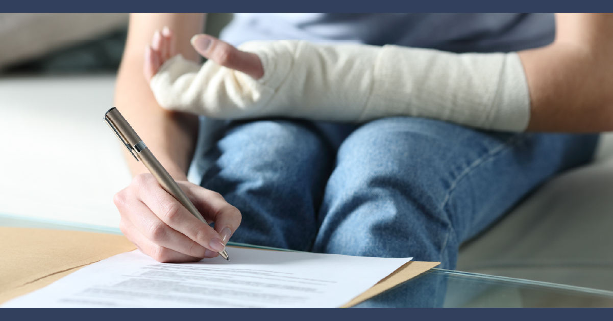 Person wearing a wrist cast signing paperwork
