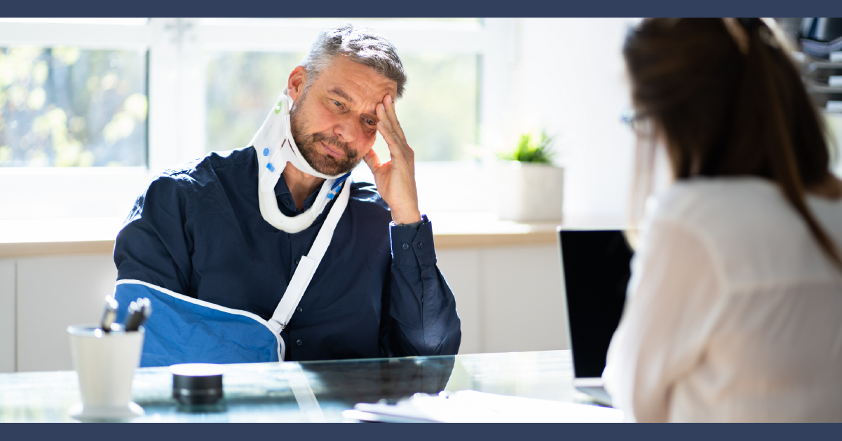 Manin neck brace and arm cast meeting with lawyer